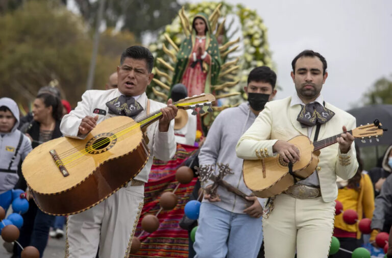 Mariachis play as participants march on East Cesar E. Chavez Avenue during the 91st annual Virgen de Guadalupe procession on Sunday in East Los Angeles.(Brian van der Brug / Los Angeles Times)